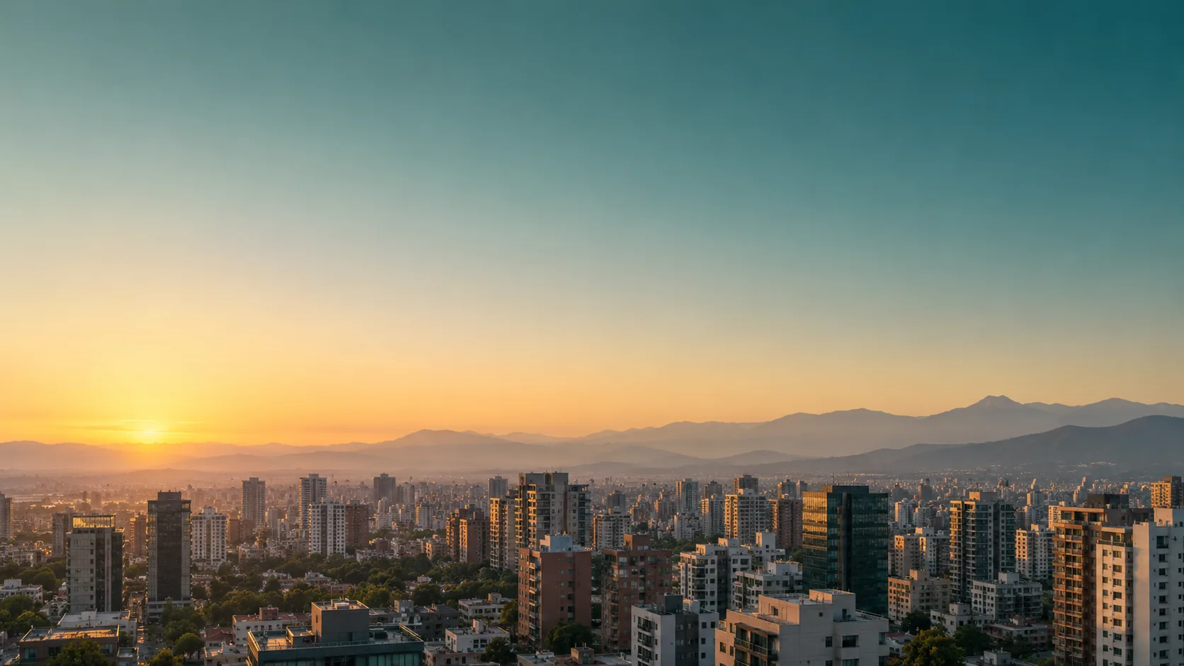 Horizonte de una ciudad al amanecer con montañas al fondo